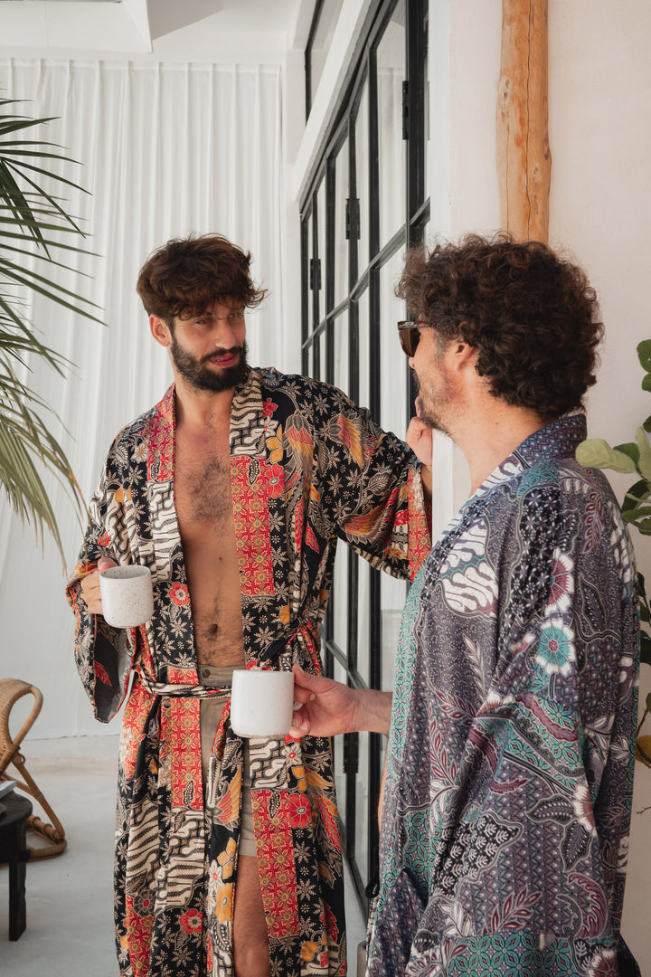 Two men in luxurious men’s silk kimonos, standing and drinking coffee.