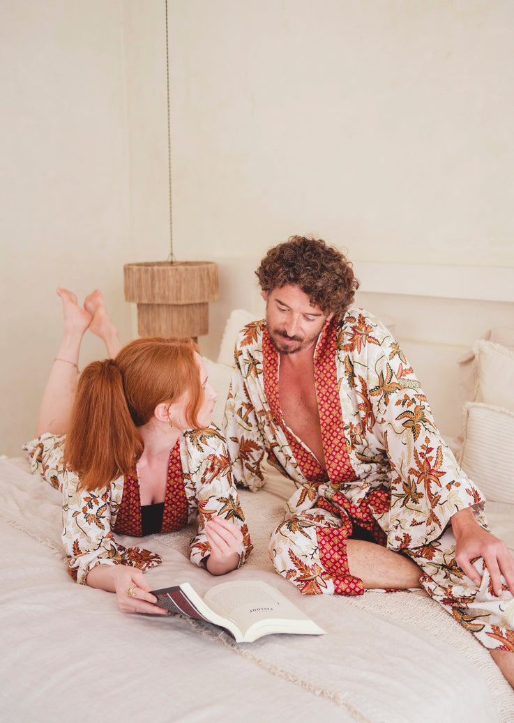 a couple laying on a bed wearing bali silk kimono robe