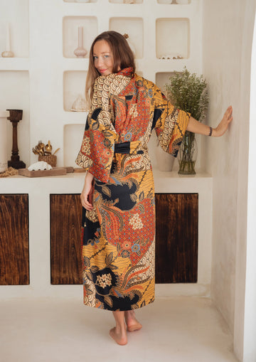 A woman wearing Balinese orange/yellow/black Silk Kimono Robe